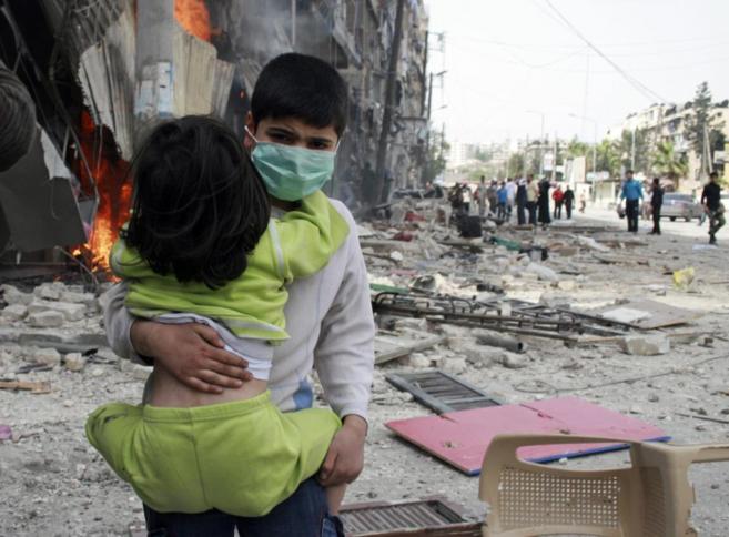 Un nio lleva a una nia tras un ataque en la ciudad de Alepo.