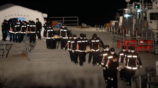 Los equipos de rescate surcoreanos trasladan varios de los cadveres...