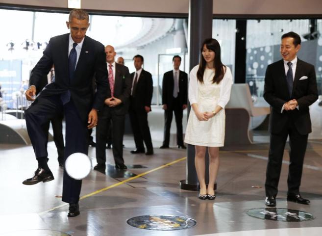 El presidente de los EEUU, Barack Obama, recibiendo el pase del robot...