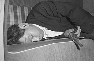 Un hombre desplomado en un sof tras dispararse en la cabeza en 1950.
