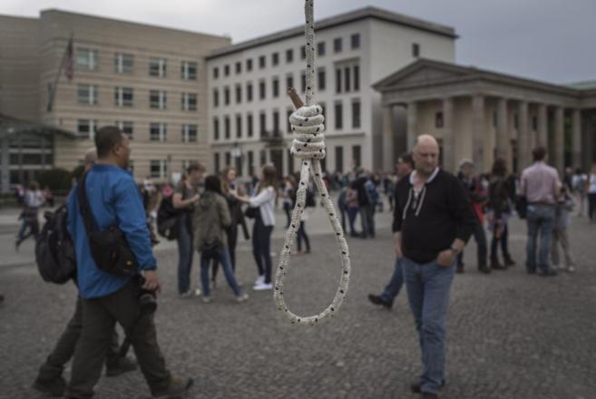 Turistas frente a una soga colocada en Berlín por exiliados iraníes...