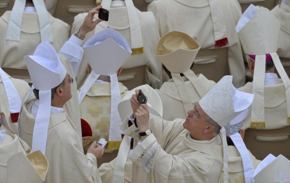 Dos obispos toman fotos con su mvil del histrico momento.