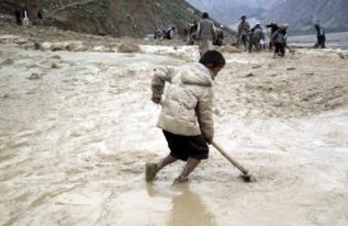 Varias personas limpian de barro en Badakhshan.