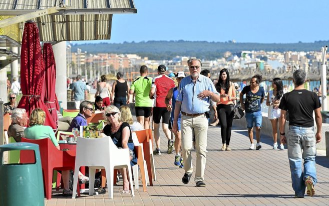 Turistas nacionales e internacionales paseando por Playa de Palma...
