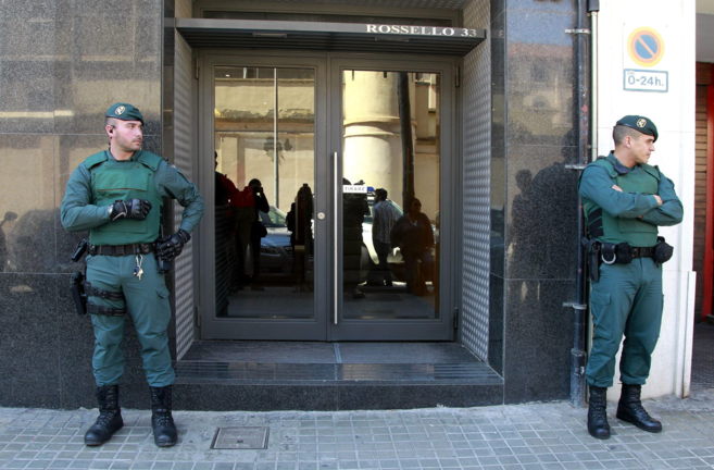Agentes de la Guardia Civil custodian el acceso a la sede en Barcelona...