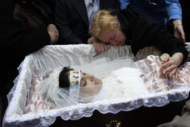 La madre de una víctima en Kramatorsk llora ante el cadáver de su...