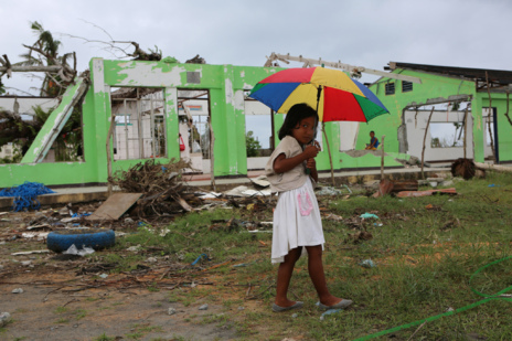 Una nia delante de su escuela destruida en Tanauan.