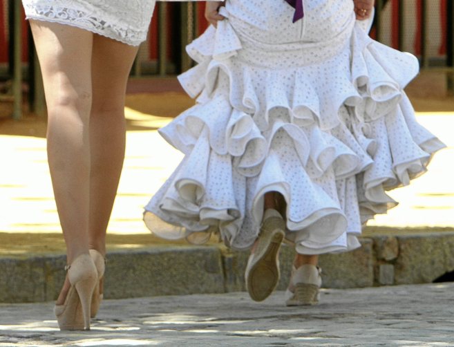 Dos mujeres, una vestida de gitana y otra con minifalda, en el real de...