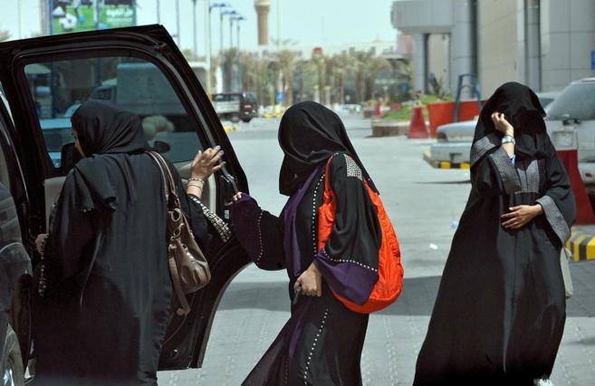 Mujeres saudes suben al asiento trasero de un coche, en la capital...