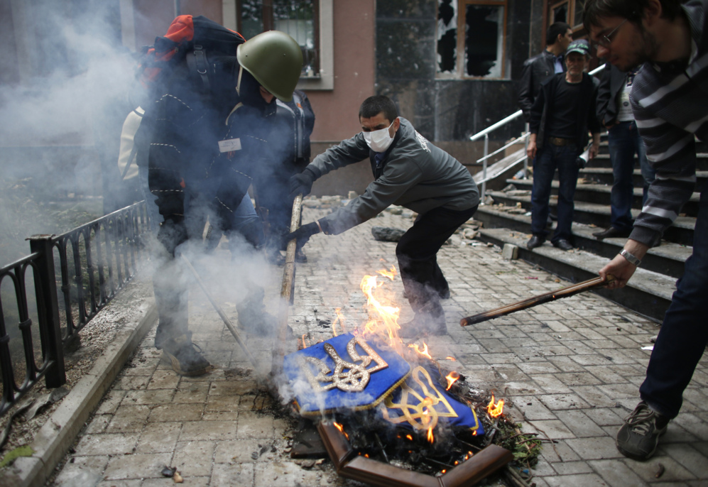 1 de Mayo de 2014. Activistas pro-rusos queman un escudo de armas de...