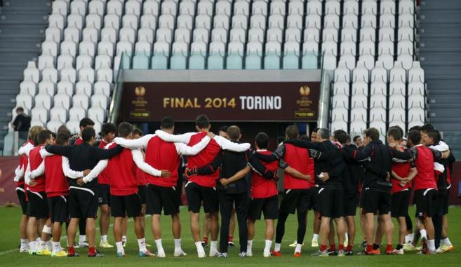 Los jugadores del Sevilla, abrazados, escuchan a Unai Emery en Turn.