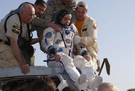 El cosmonauta ruso Mikhail Tyurin recibe ayuda a su salida de la...