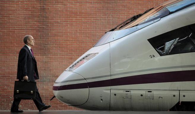 Un viajero se dispone a subir a un tren AVE con destino a Barcelona,...