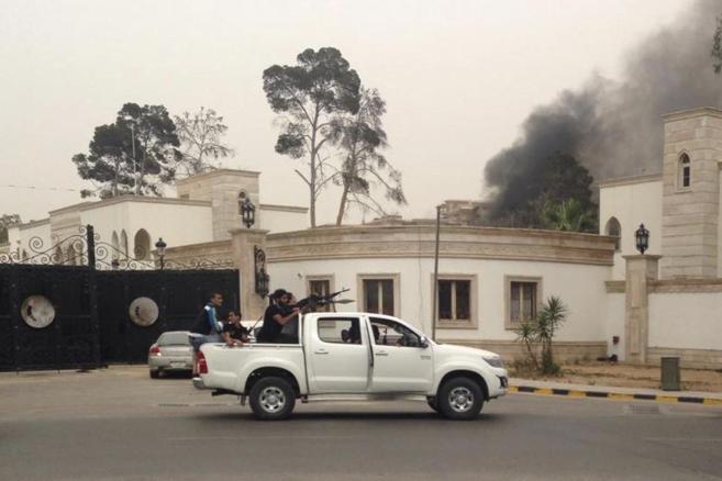 Sale humo del Parlamento libio mientras unos hombres armados salen en...