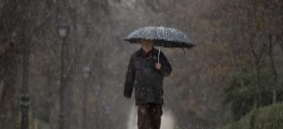 Un hombre pasea bajo la lluvia en el Parque del Retiro, en Madrid.