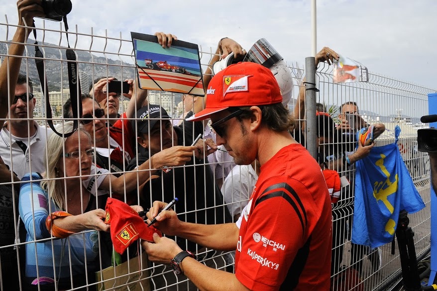 Fernando Alonso firma autógrafos a los aficionados en Mónaco.
