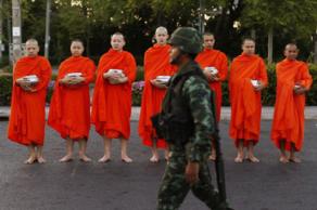 Un soldado, frente a monjes budistas.