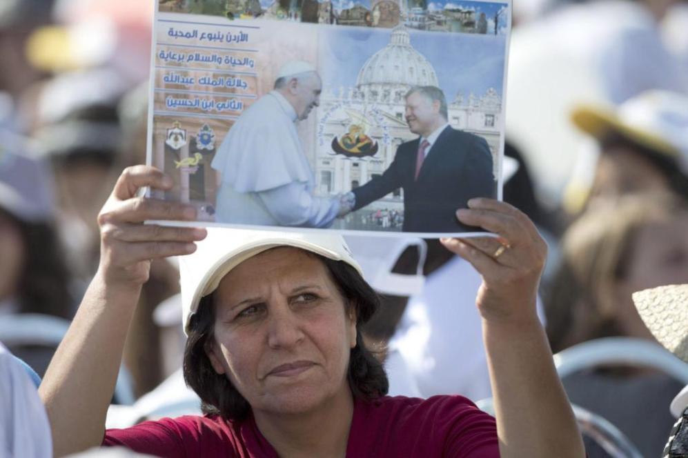 Una mujer con con cartel donde aparece el Papa Francisco.