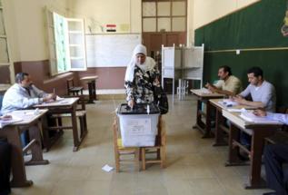 Una mujer egipcia vota en un colegio