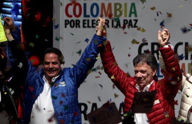 El candidato a la reeleccin Juan Manuel Santos levanta los brazos...