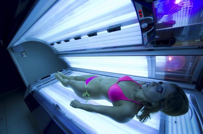 Una mujer se broncea en el interior de una cabina de rayos UVA.