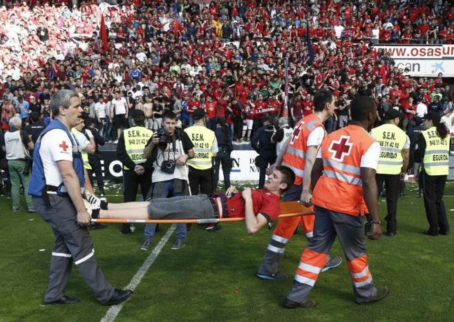 Efectivos de Cruz Roja trasladan a un aficionado del Osasuna tras el...