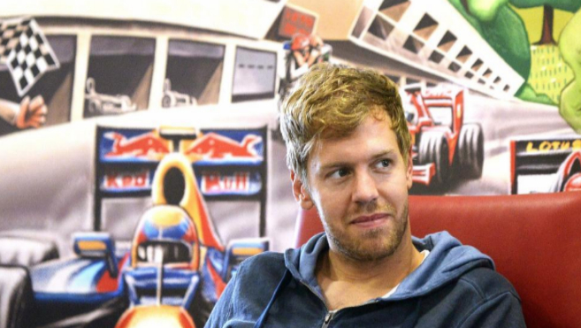 Sebastian Vettel, posa con una imagen de Red Bull a su espalda.
