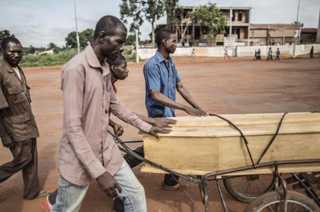 Un grupo de hombres lleva el ataúd de un hombre asesinado en Bangui...