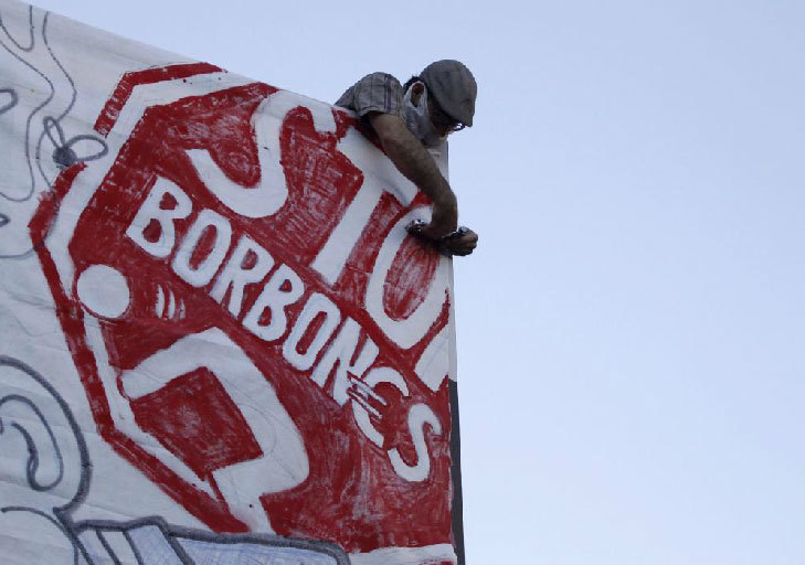 Un hombre coloca un cartel con la leyenda 'Stop Borbones' en el centro...