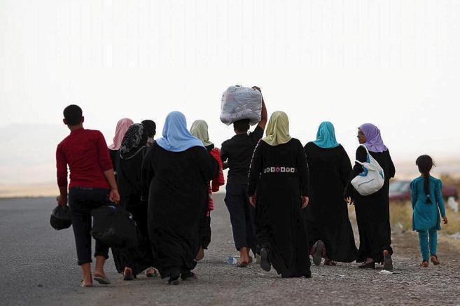 Refugiados iraquíes huyen tras los recientes ataques de ISIS, en...
