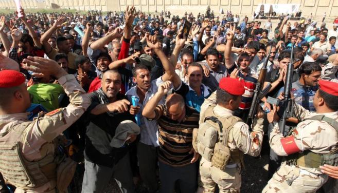 Decenas de voluntarios iraquíes esperan a ser trasladados a un campo...