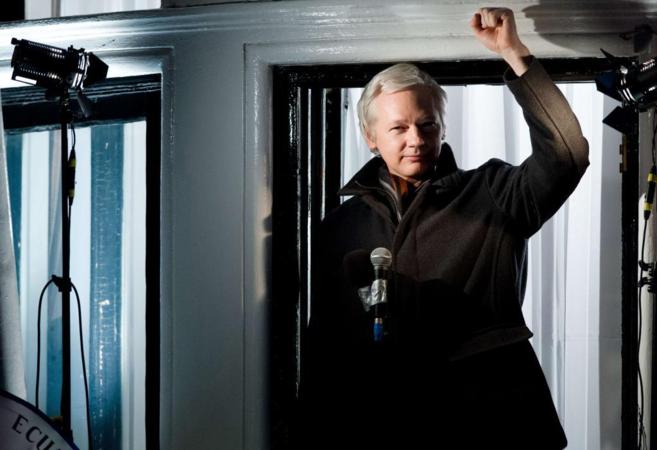 Julian Assange saluda desde una de las ventana de la embajada de...