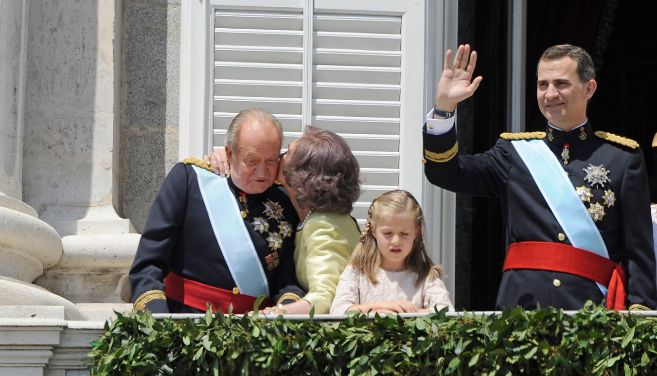 La Reina besa al Rey, mientras su hijo saluda al pueblo.