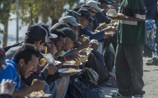 Decenas de mexicanos, deportados desde EEUU, comen alimentos donados...