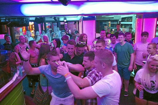 Jvenes britnicos bebiendo y divirtindose en grupo en un bar de...