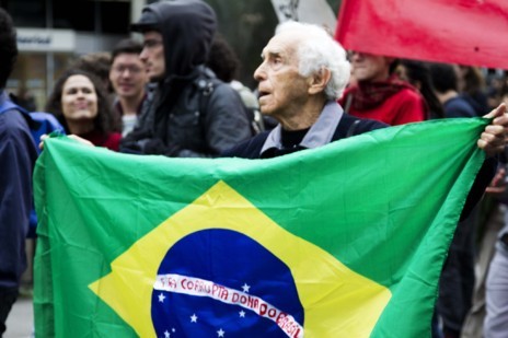 Un seor sujeta una bandera de Brasil con un lema contra la...