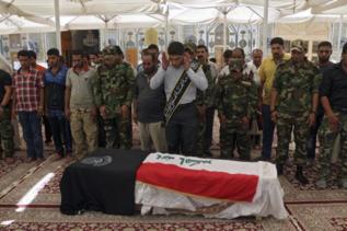 Miembros de una milicia chi  velan a un combatiente muerto.
