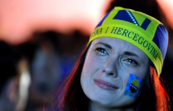 Una aficionada bosnia llora tras la derrota de su equipo.