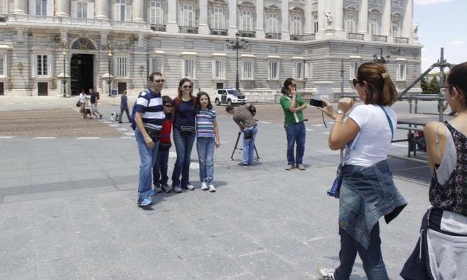 Un grupo de turistas se hace una foto frente al Palacio Real el da...