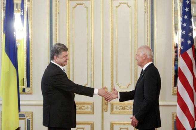 El presidente ucraniano, Poroshenko (izda.), saluda al vicepresidente...