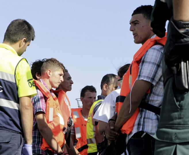 Varios inmigrantes a bordo de la lancha de la Guardia Civil que les ha...