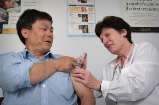 Un hombre recibe una vacuna contra la tos ferina.