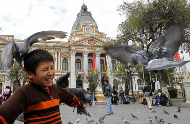 Un nio juega con las palomas en la plaza Murillo de La Paz.