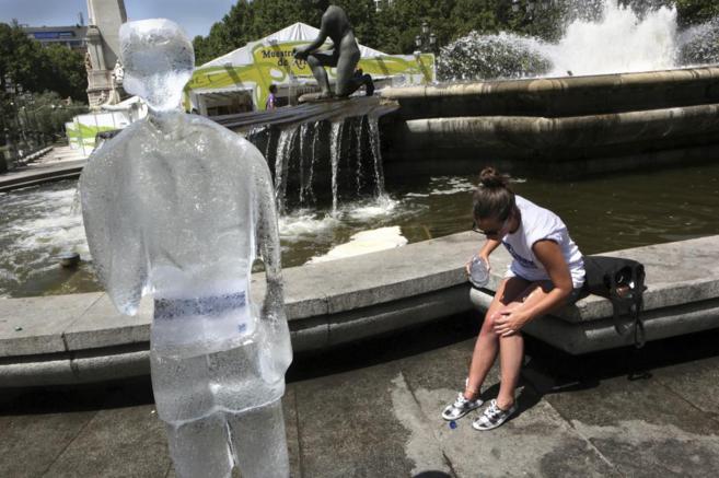Una figura de hielo en una fuente de Madrid donde una joven se...