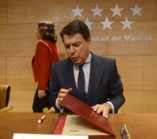 Ignacio Gonzlez abre una carpeta mientras Ana Botella pasa por...