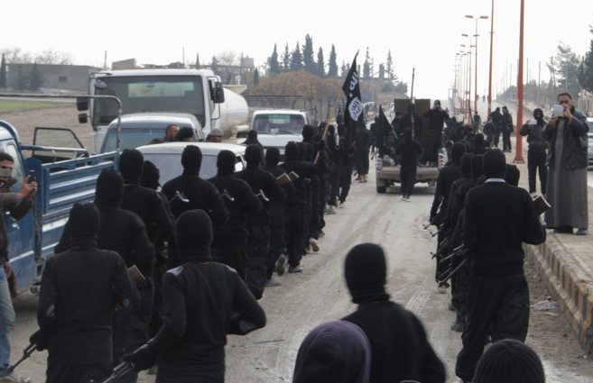 Milicianos del ISIS, vinculado a Al Qaeda, desfilan por las calles de...