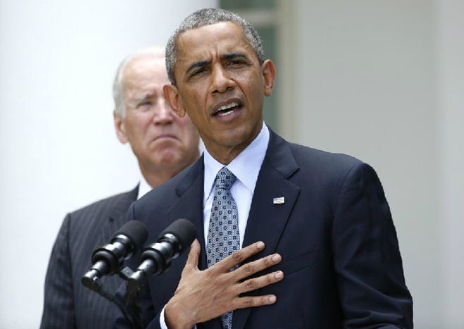 Obama, con el vicepresidente Biden a su espalda, durante su...