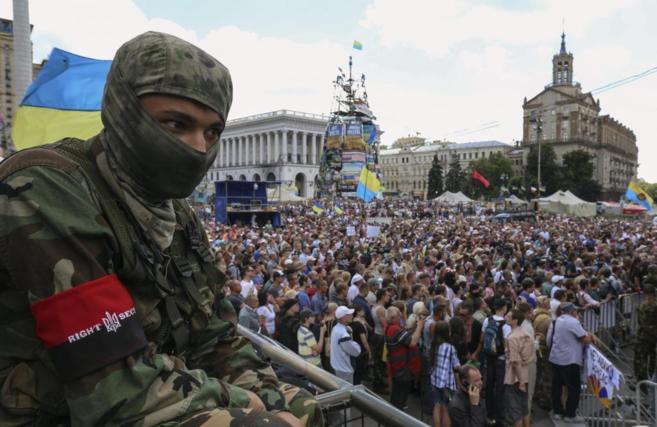 Un soldado ucraniano observa la protestas en la Plaza de la...