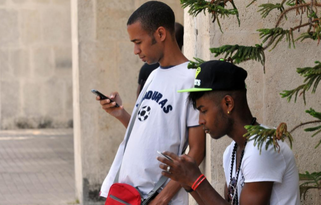 Dos jvenes cubanos consultan sus telfonos mviles en La Habana.