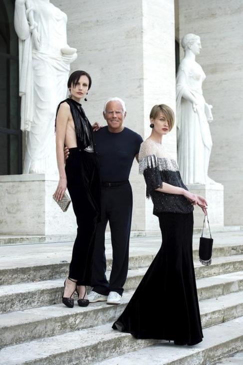 Giorgio Armani posa con dos de sus modelos.